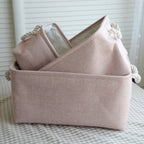 Paniers de rangement en tissu empilables rose posés sur un tapis de trois taille différentes S/M/L 
